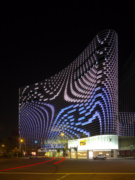 Vertical Shot Of A Louis Vuitton Banner On A Building At Night In